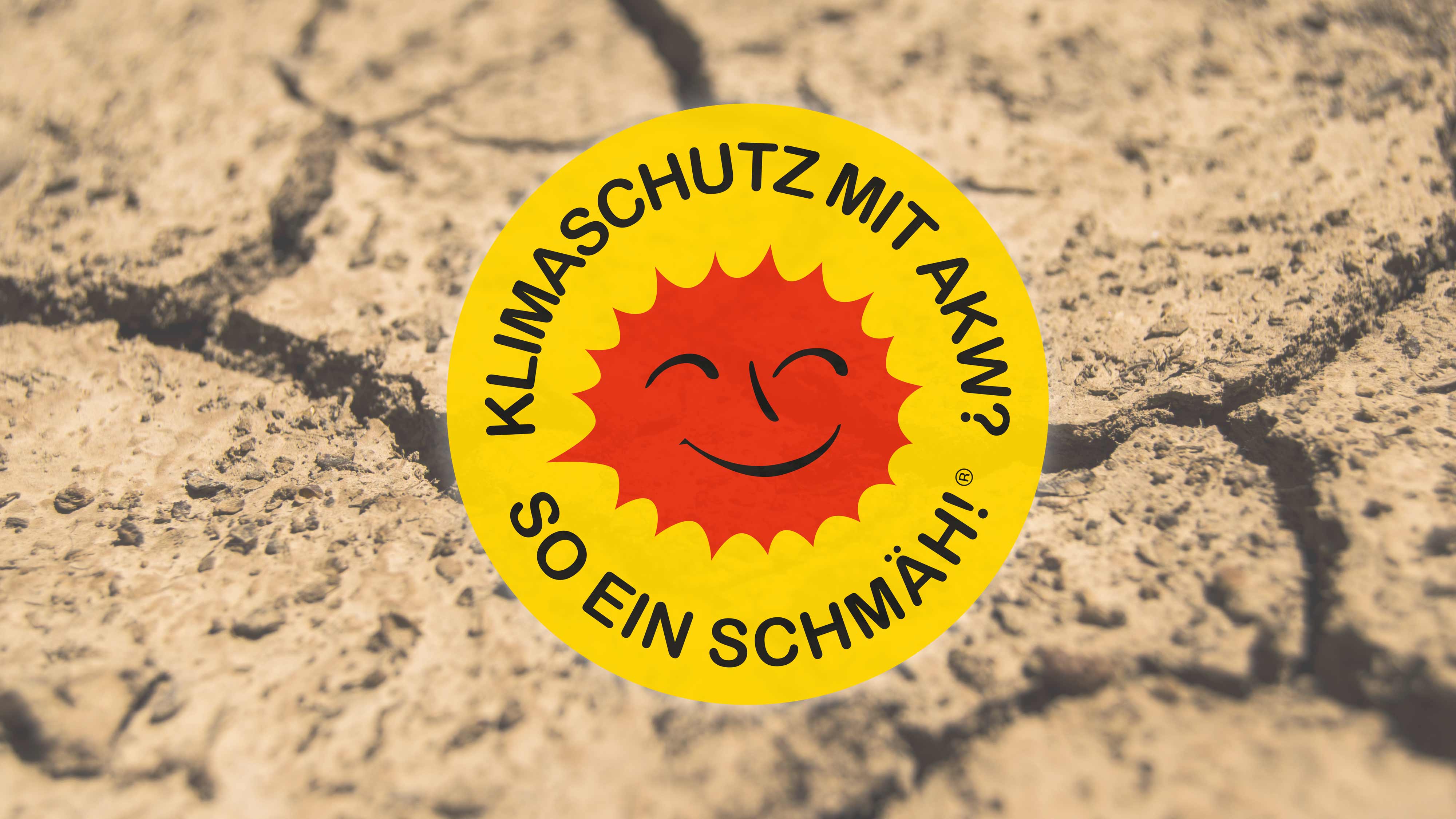 Klimaschutz mit AKW? So ein Schmäh! -Sticker auf ausgetrocknet-rissigem Feld