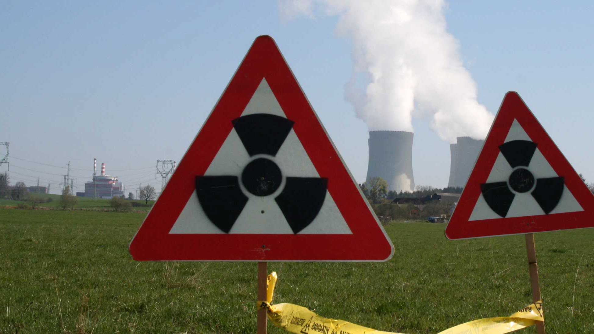 2 "Achtung Radioaktiv"-Schilder, im Hintergrund die Kühltürme des AKW Temelin